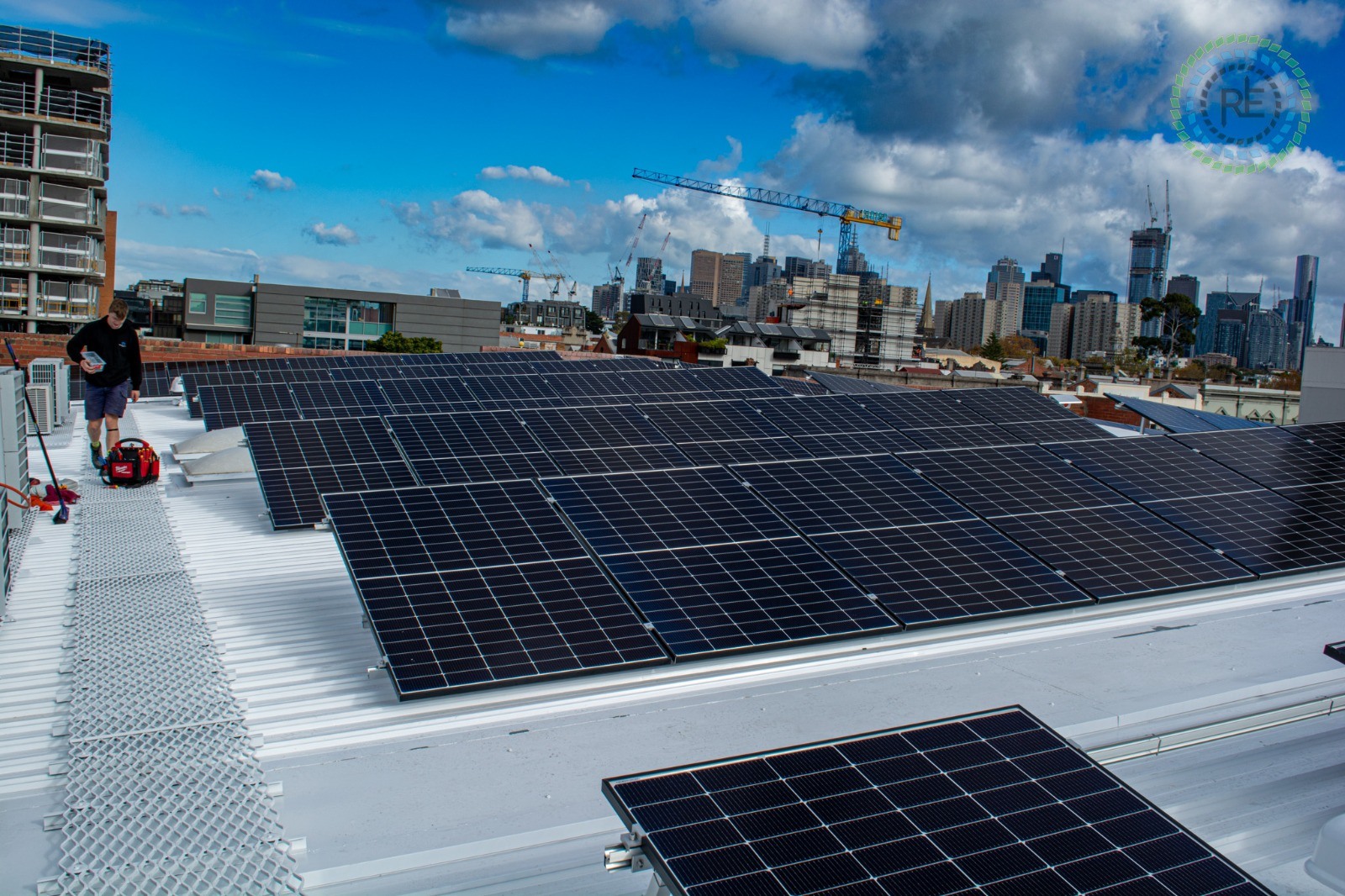 Commercial rooftop solar array installed by HP Energy on an inner-city building, with the Melbourne skyline behind it